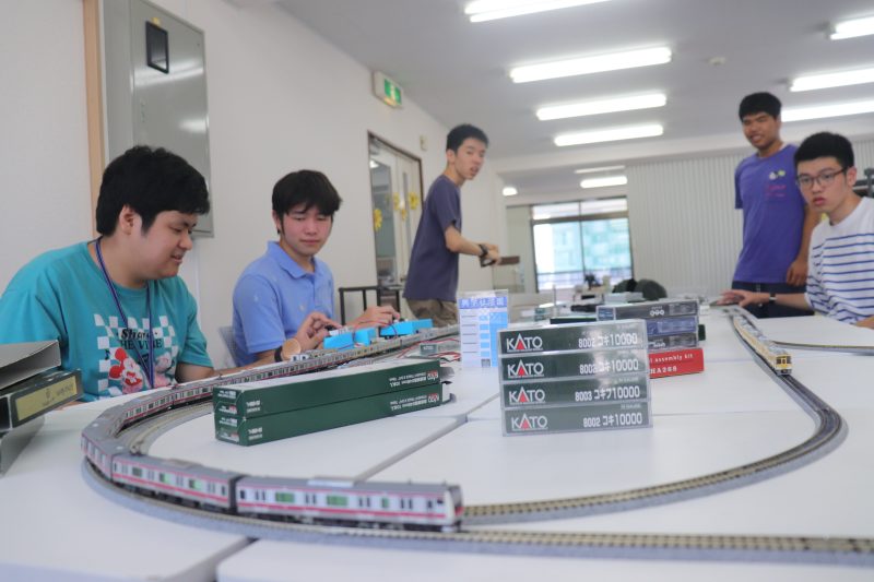 鉄道研究部の活動写真：模型や資料を囲む生徒